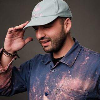 Coiffeuse en veste Olivia Garden avec casquette, mettant en valeur des outils de haute qualité. Focus sur le style et le professionnalisme.